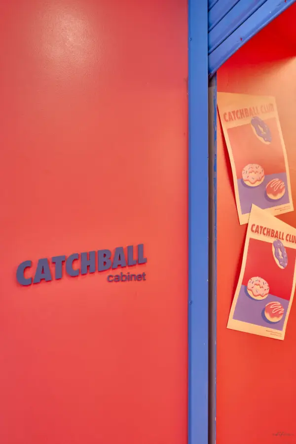 코랄 벽면과 블루 레터링의 브랜드 사이니지 디테일